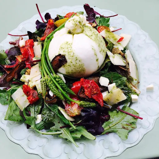 Burrata sur lit de jeunes pousses et légumes confits